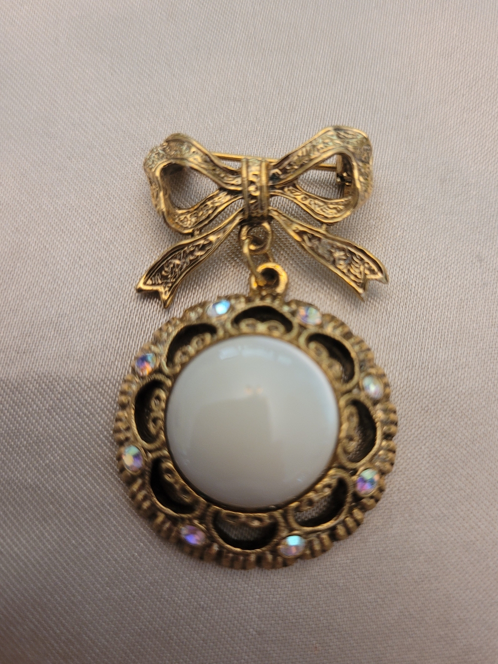 1928 Jewelry Compqny Golden Bow Pendant Brooch with Cream Cabochon